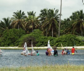 Homens em uma lagoa competindo com jangadas